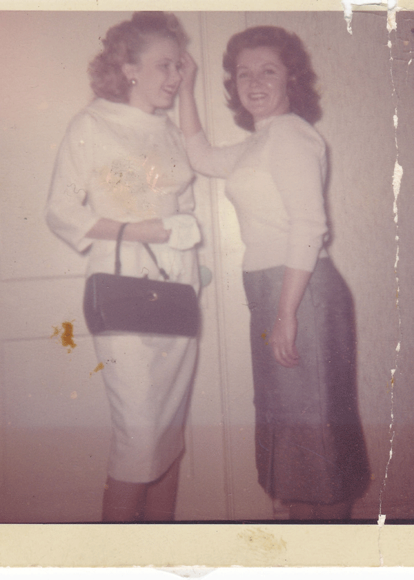 Faded colour photograph of two women with discolouration and marks
