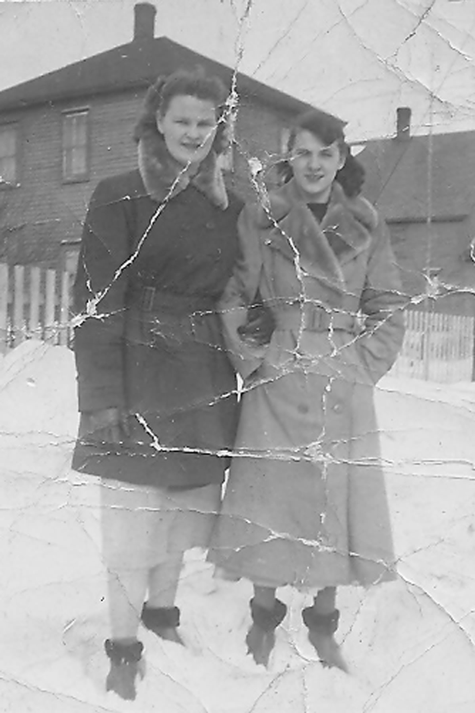 Original black and white photograph of two women with cracks and tears